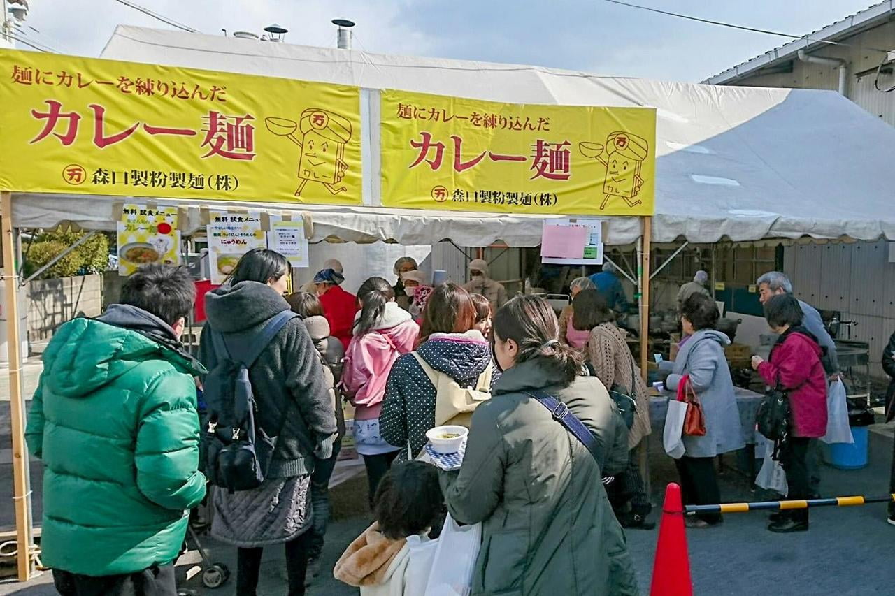 たつの市で開催されるふれあい麺まつりで振る舞われたカレー麺に並ぶ多くの人々の写真