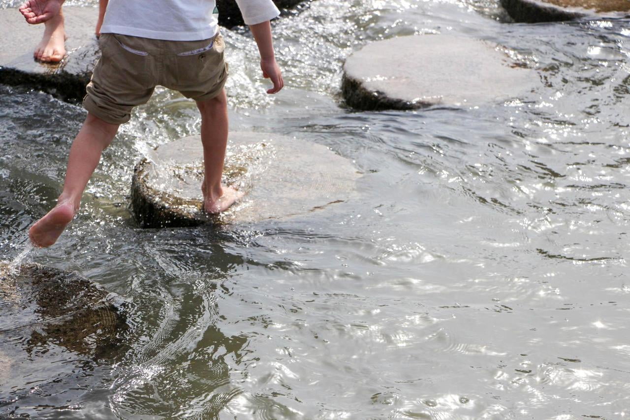 川で遊ぶ子供の足の写真