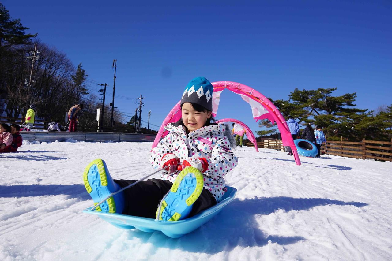 峰山高原リゾートホワイトピークのキッズエリアでソリに乗って遊ぶ女の子の写真.jpg