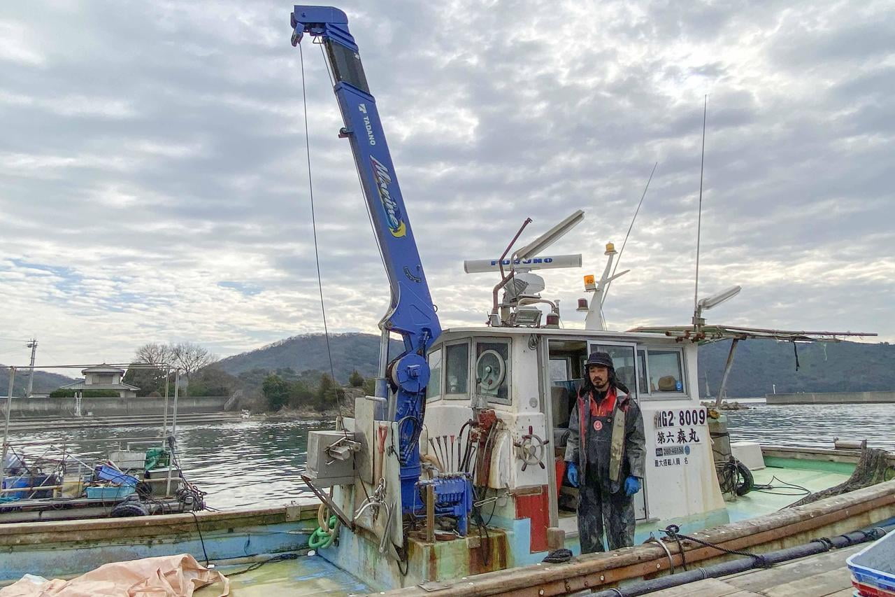 船と漁師の木元さんの写真.jpg