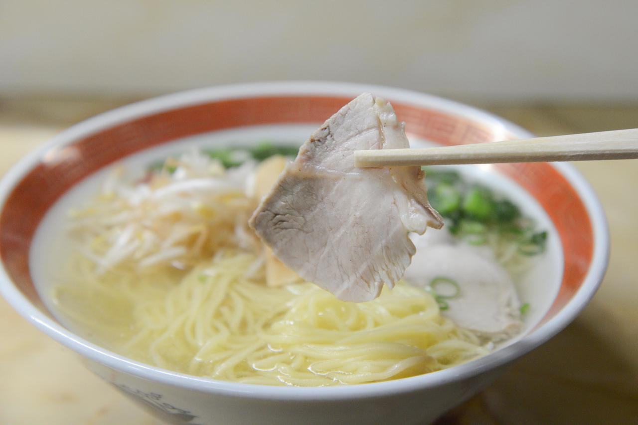 新生軒のラーメンのトッピングチャーシューを箸で持ち上げている写真.jpg