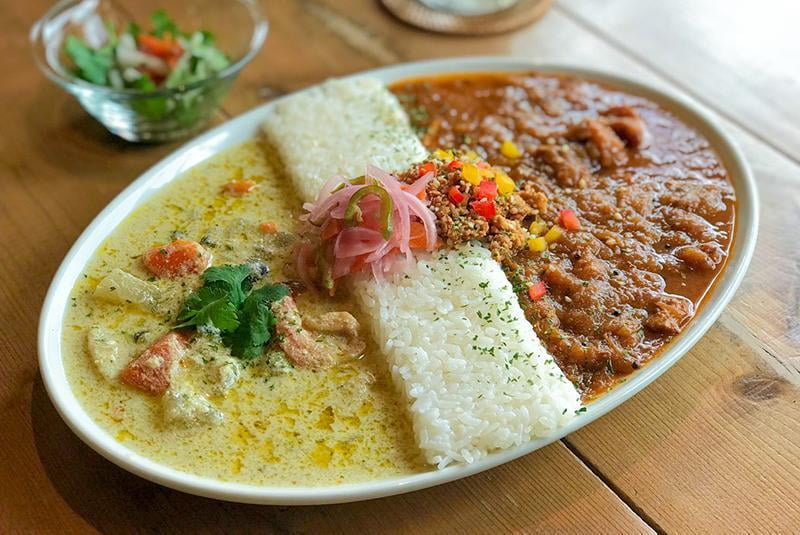 spiceスエヒロの3種の鶏のチキンカレーと海老と野菜のグリーンカレーのあいがけの写真