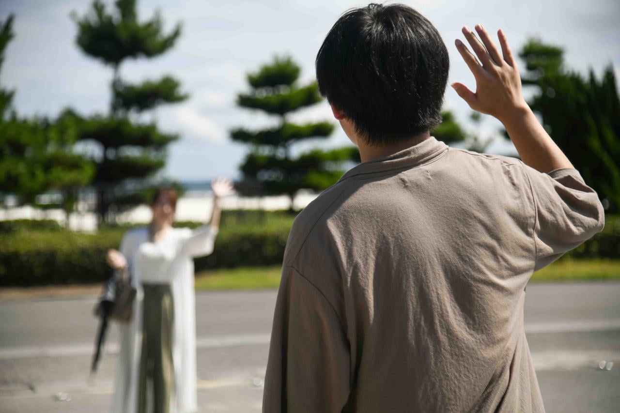駐車場で手をふる2人